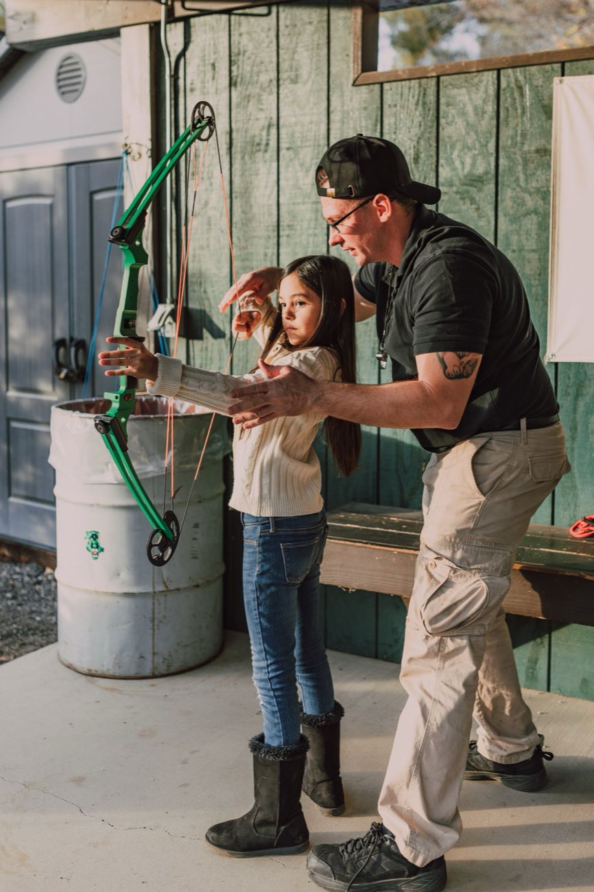 Giovane arciera seguita dall'istruttore